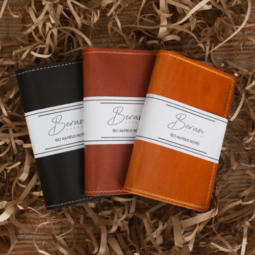 Three Leather Notepad Covers lying side by side in black, chestnut, cognac colors.