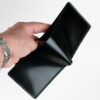 a male hand holding Shell cordovan wallet, black color.