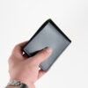 a male hand holding Shell cordovan wallet, black color.